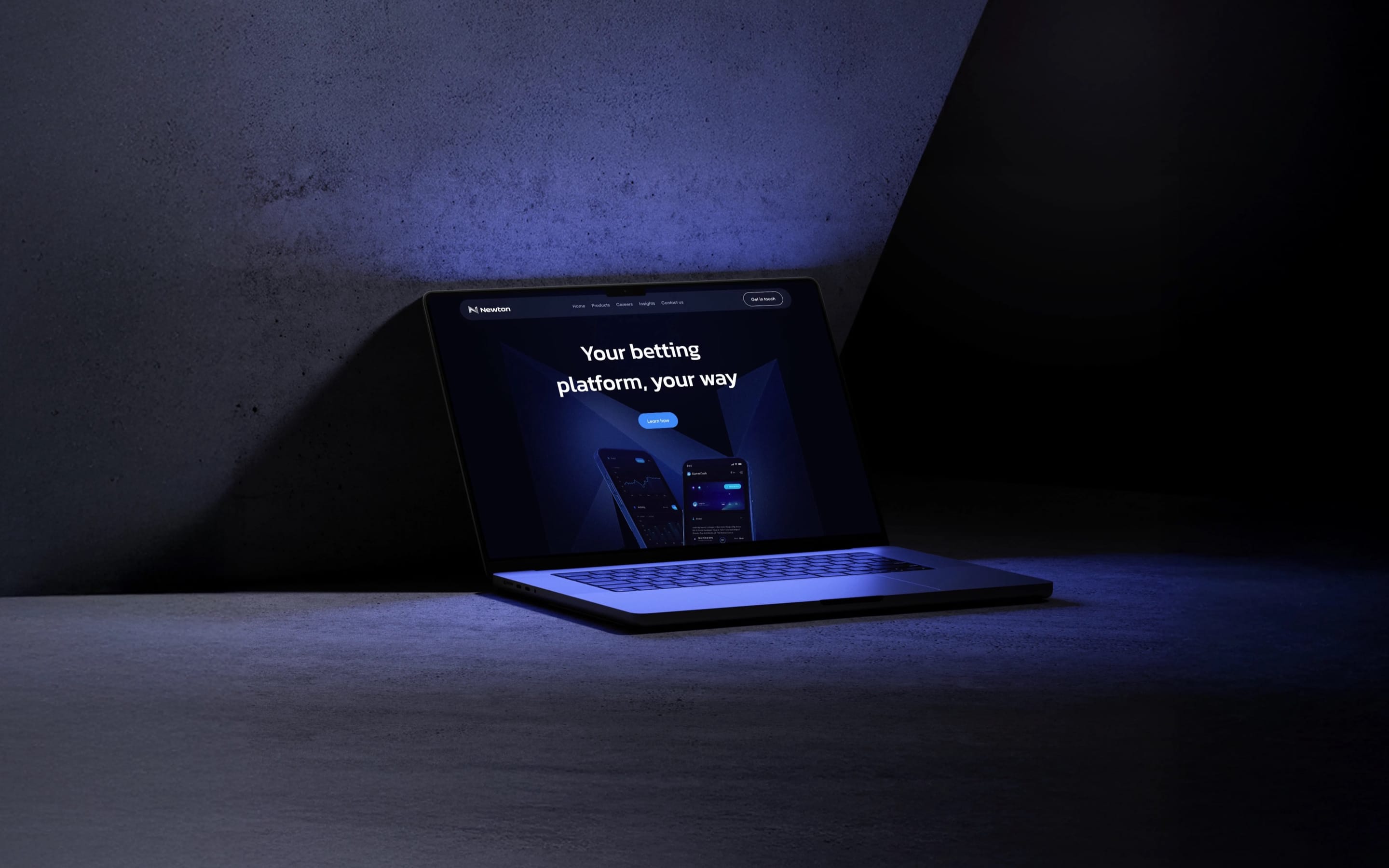 A laptop glowing blue in a dark concrete room, showing the Newton homepage: “Your betting platform, your way”.