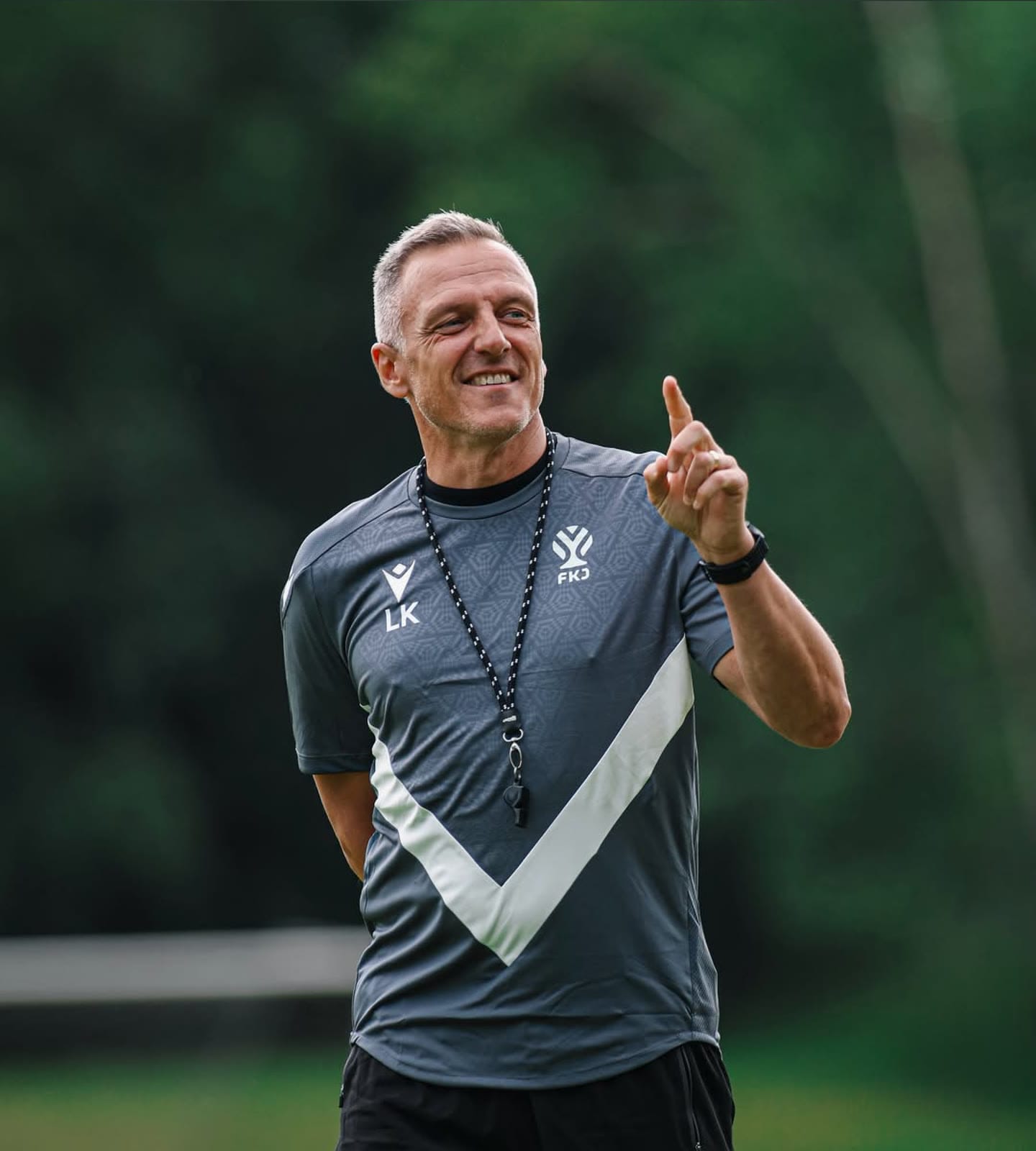 The coach at training in the grey kit with the white diagonal cut and the new symbol.