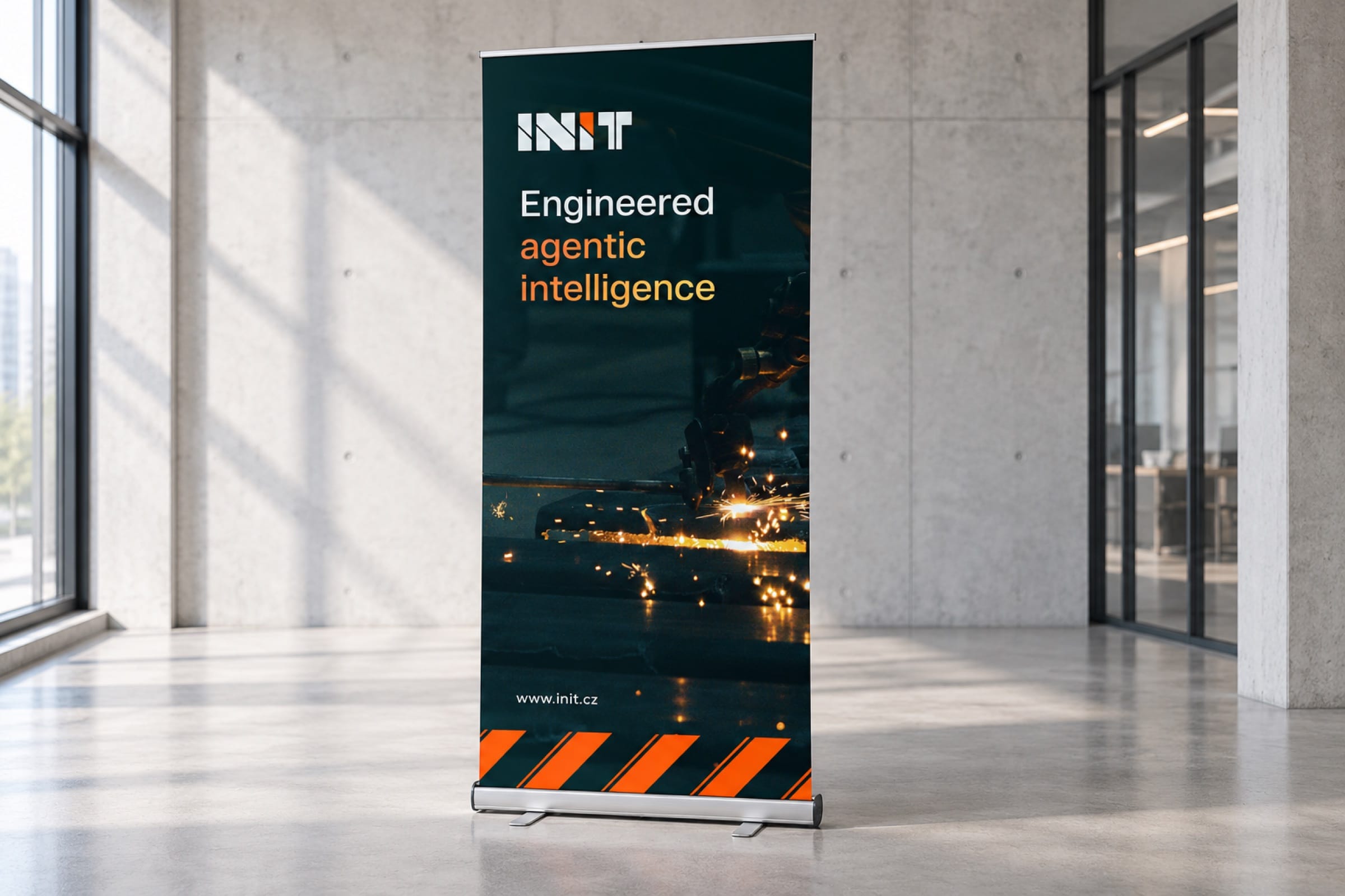 A roll-up banner in a sunlit concrete lobby: Engineered agentic intelligence over sparks on a production line.